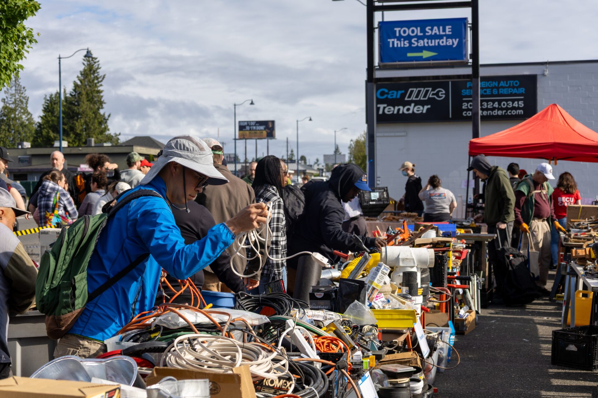 Folks looking through tools organized on tables at the Shoreline Tool Library Tool Sale.