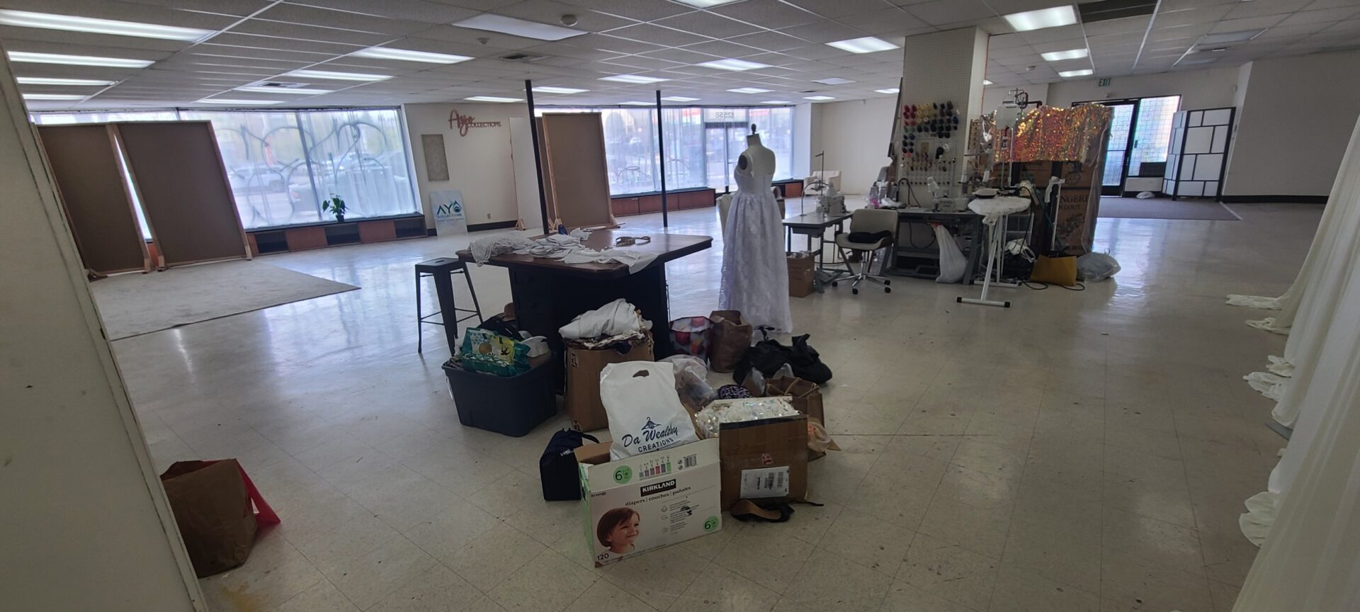 Some fabrics and art supplies sit int he middle of a rather empty space.