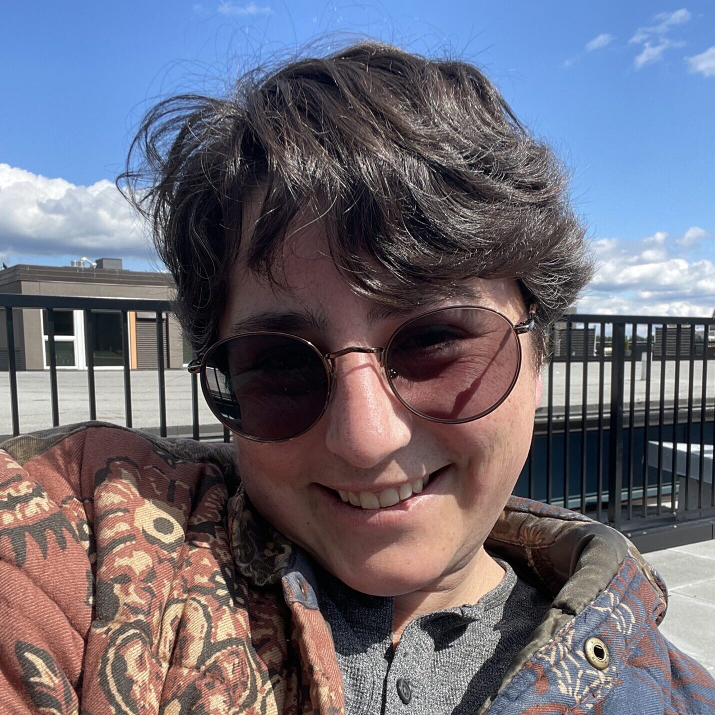 Sept smiles at the camera with sunglasses and a fun jacket on.