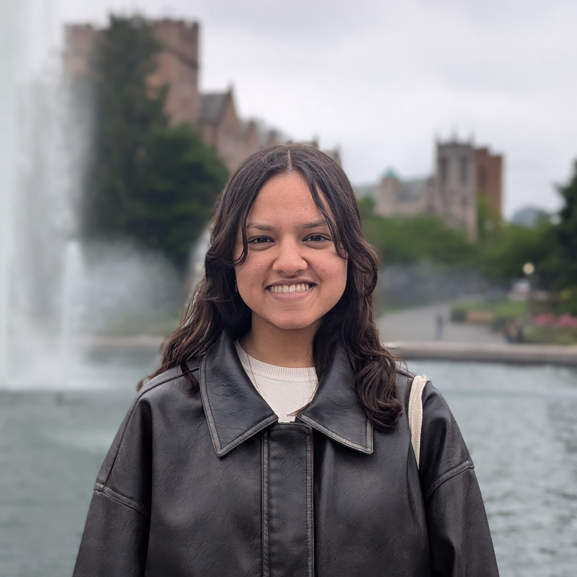 Sonali Agarwal smiles in front of a fountain.